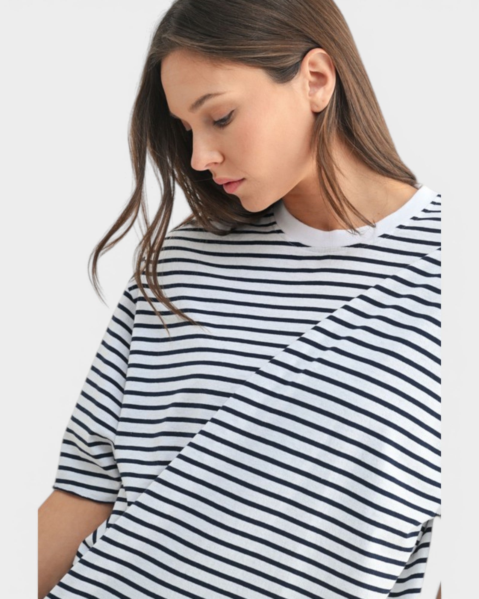 Woman wearing a black and white striped shirt on a plain background
