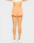 Person wearing peach shorts on a plain background
