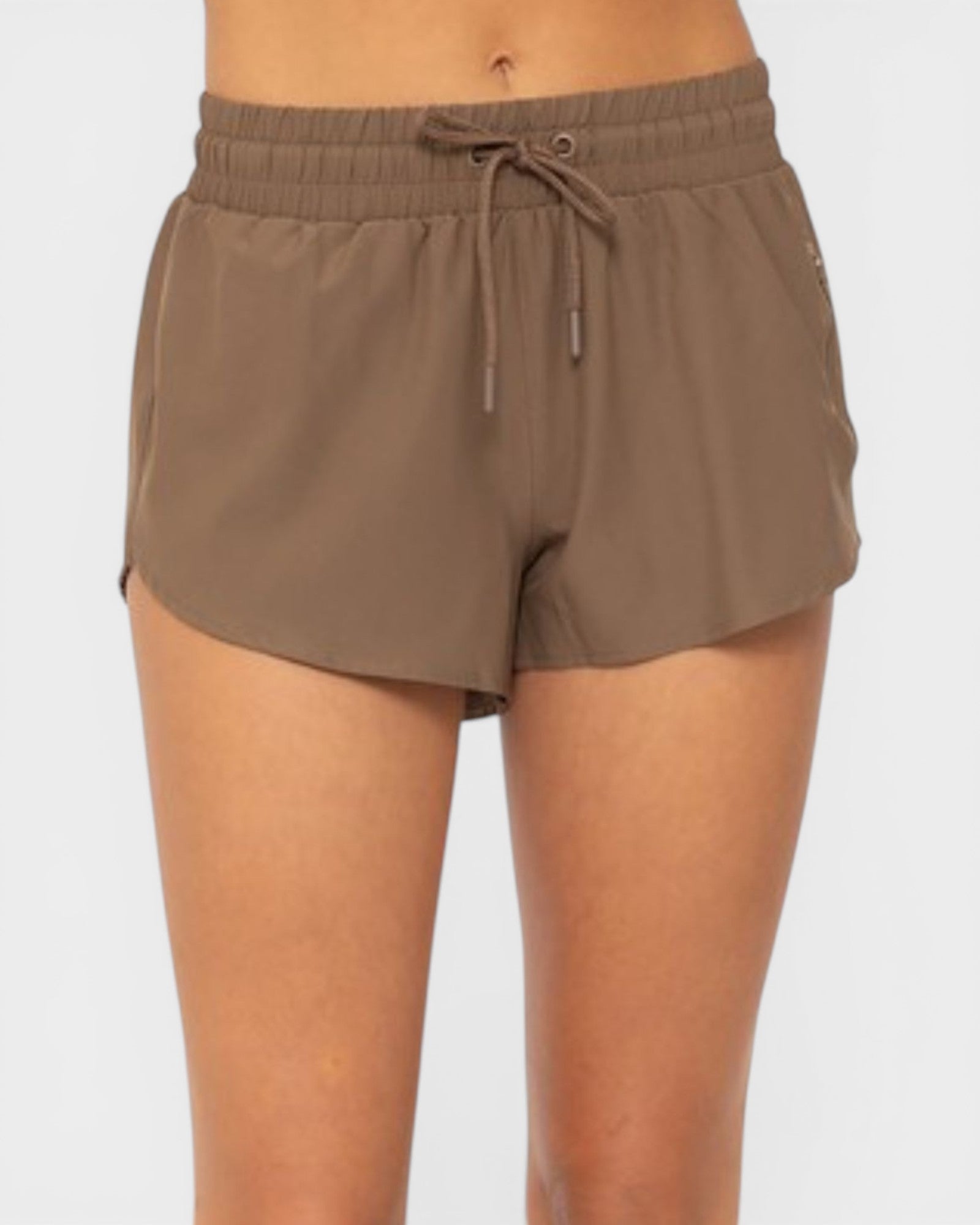 Brown shorts worn by a person on a white background