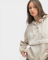 Woman wearing a beige hoodie on a light gray background