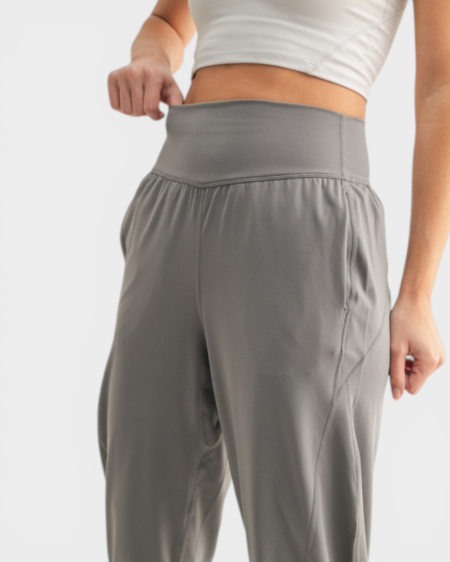 Person wearing gray athletic pants on a light gray background