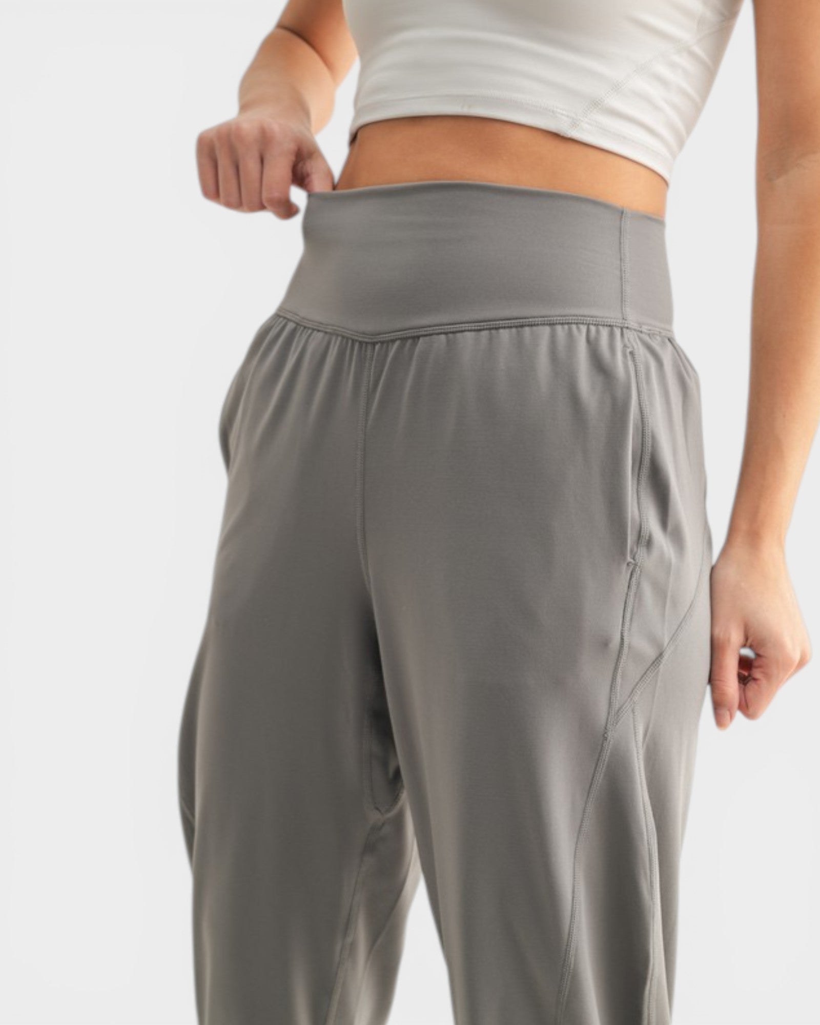 Person wearing gray athletic pants on a light gray background
