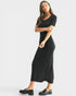 Woman wearing a black dress on a light gray background