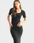 Woman wearing a black dress against a plain background