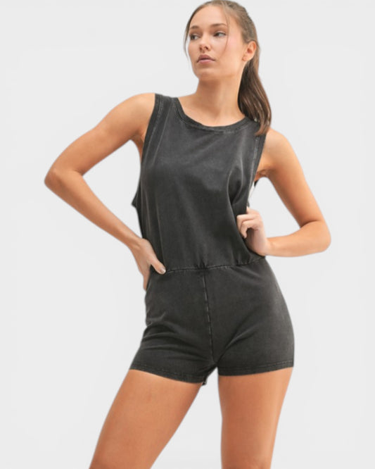 Woman wearing a black sleeveless top and shorts on a white background