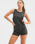 Woman wearing a black sleeveless top and shorts on a white background