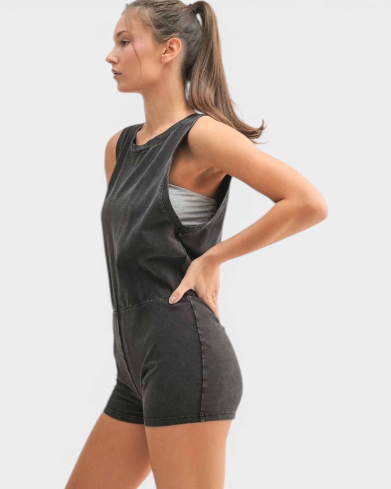 Woman wearing a black romper with a gray panel on a white background