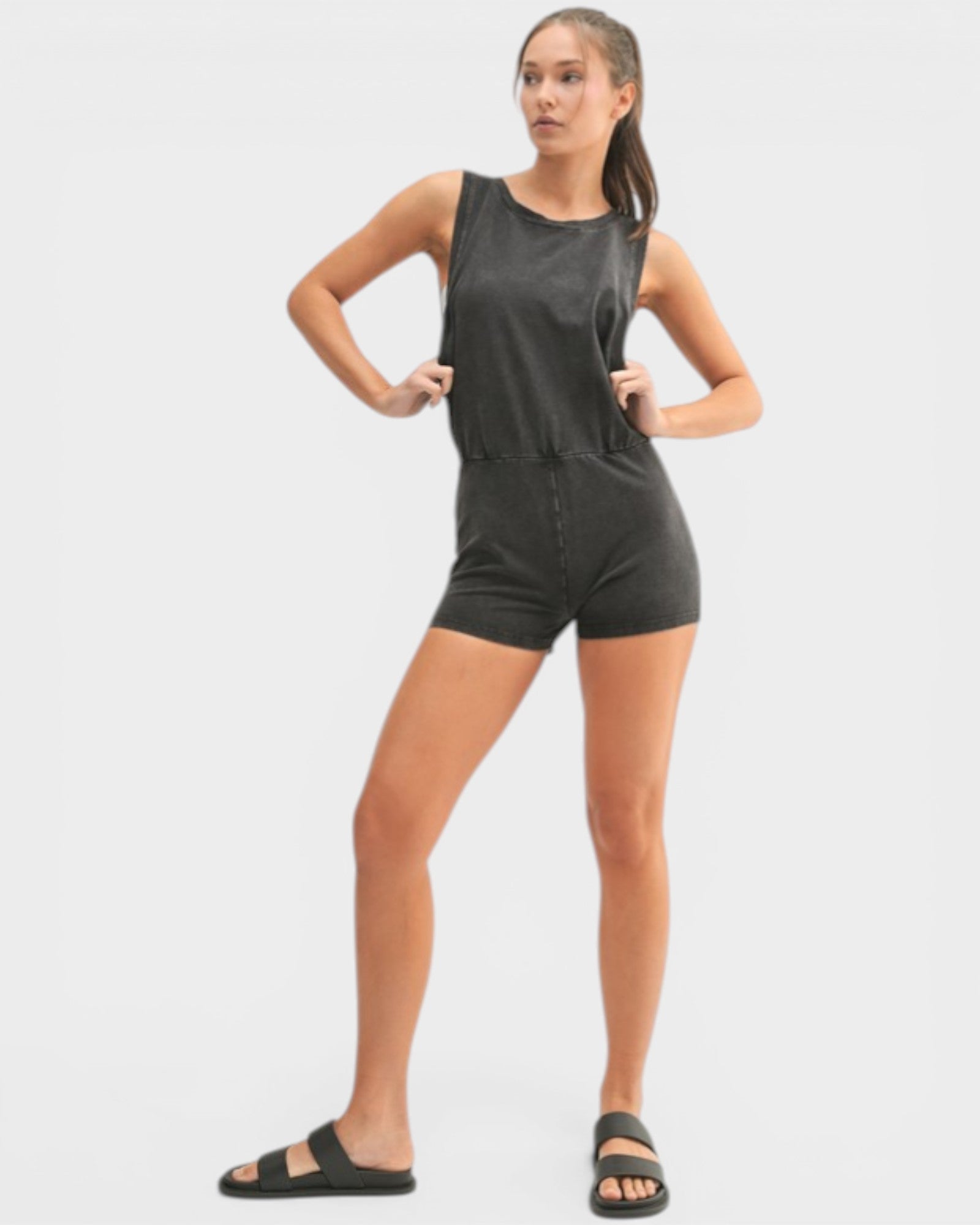 Woman wearing a black sleeveless romper on a white background