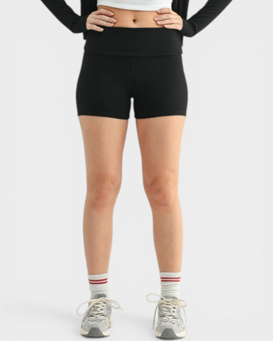 Person wearing black high-waisted shorts on a white background