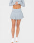 Person wearing a light blue skirt and sweater on a white background