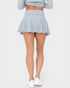 Person wearing a light blue skirt on a white background
