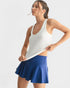 Woman wearing a white tank top and blue skirt on a light gray background