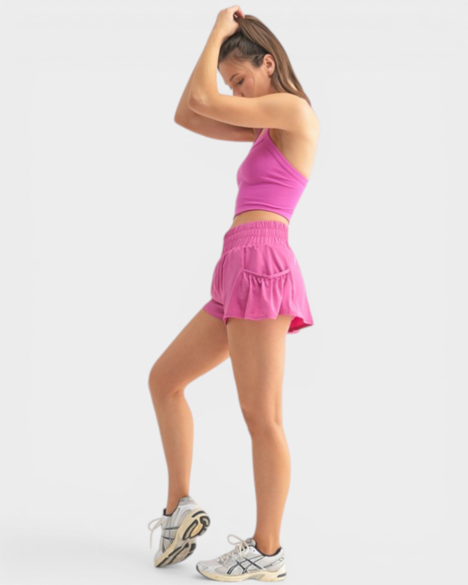 Woman wearing a pink athletic outfit on a white background