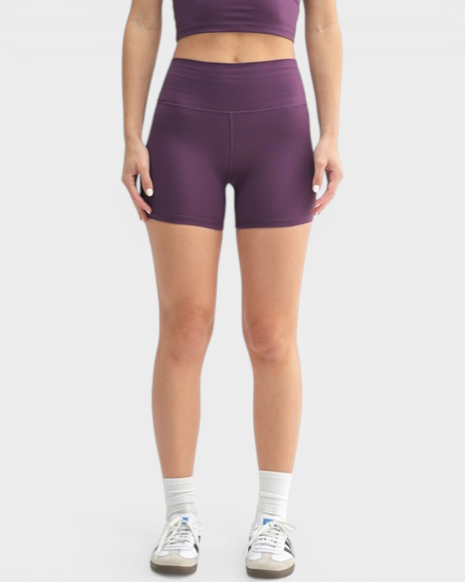 Person wearing purple athletic shorts on a white background