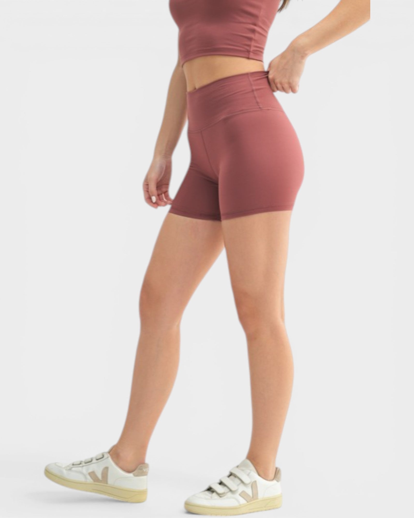 Person wearing maroon athletic shorts on a light gray background