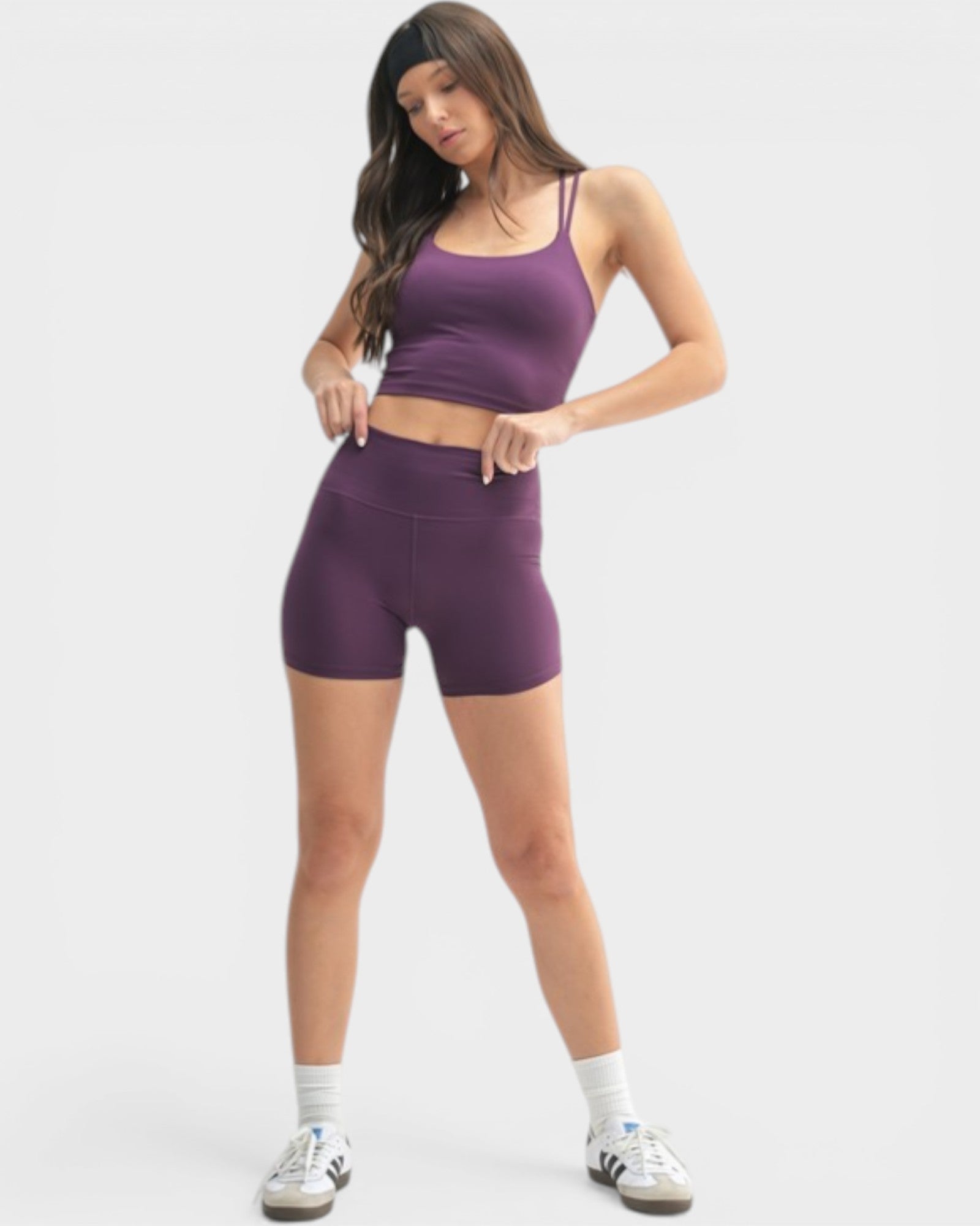 Woman wearing a purple athletic outfit on a white background