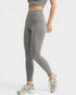 Person wearing gray leggings and sneakers on a white background