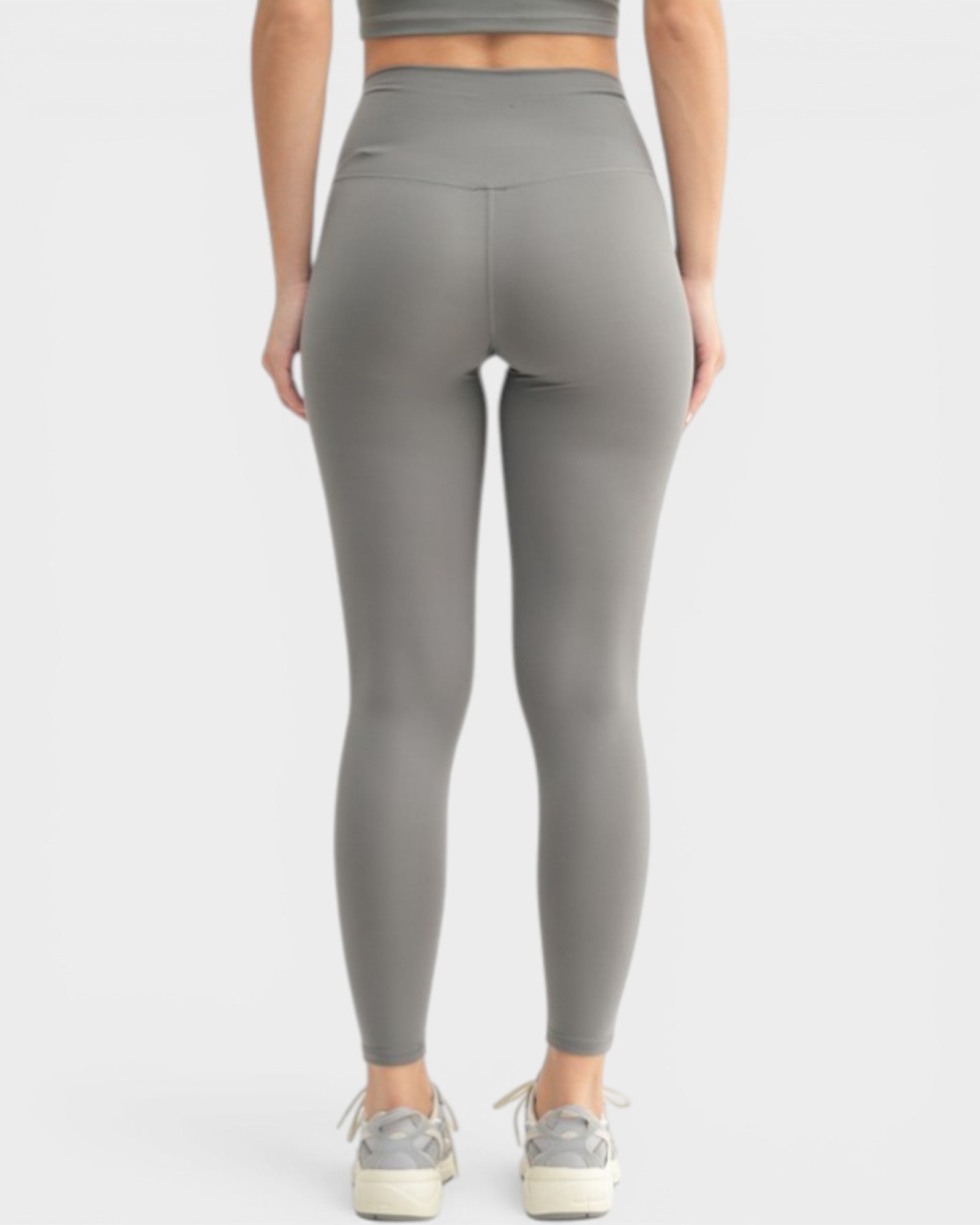Person wearing gray leggings on a white background