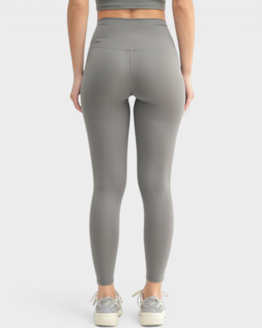 Person wearing gray leggings on a white background