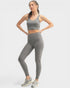 Woman wearing a gray athletic outfit on a white background