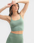 Woman wearing a green athletic outfit against a light gray background