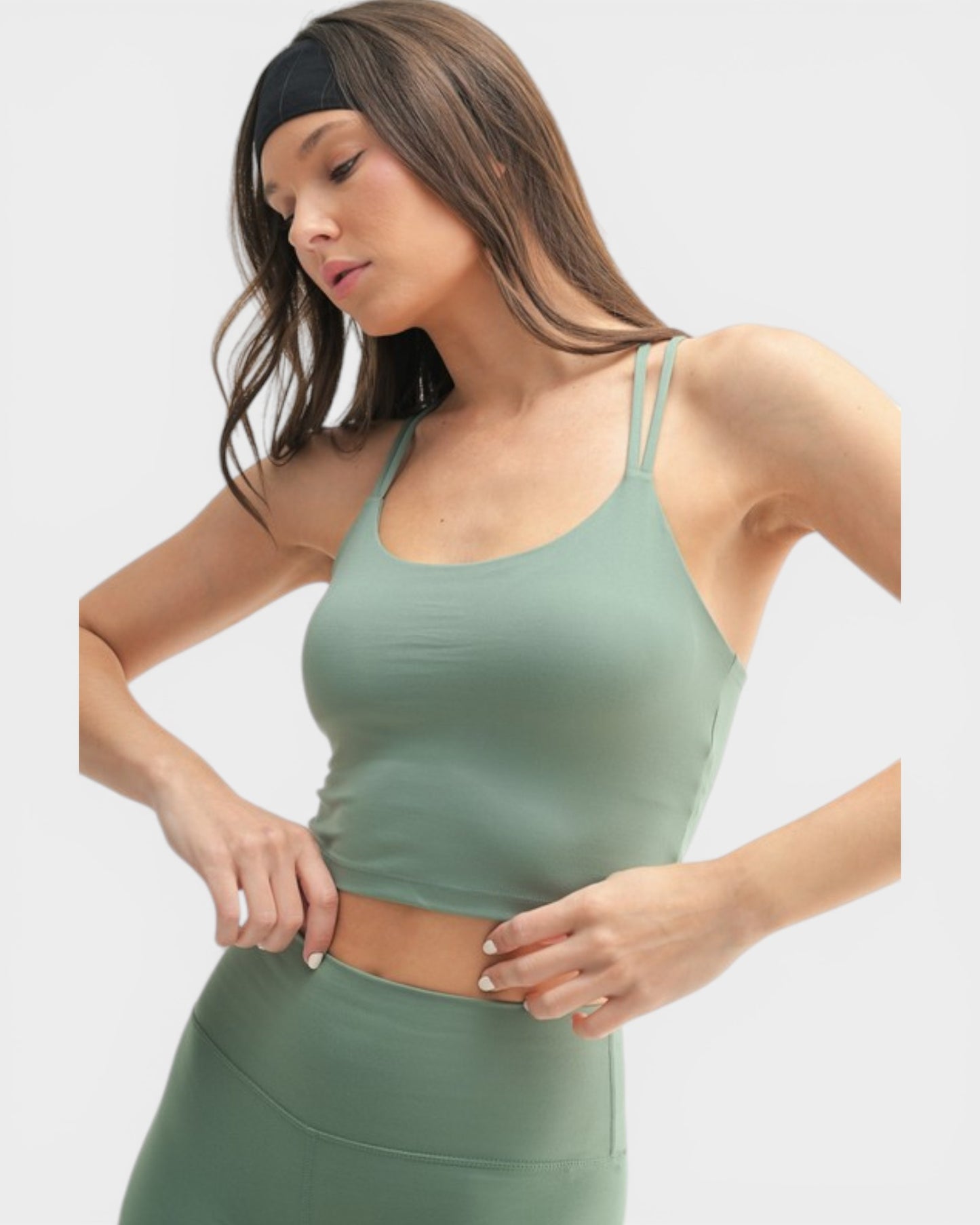Woman wearing a green athletic outfit on a white background