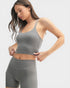 Woman wearing a gray athletic outfit on a light gray background
