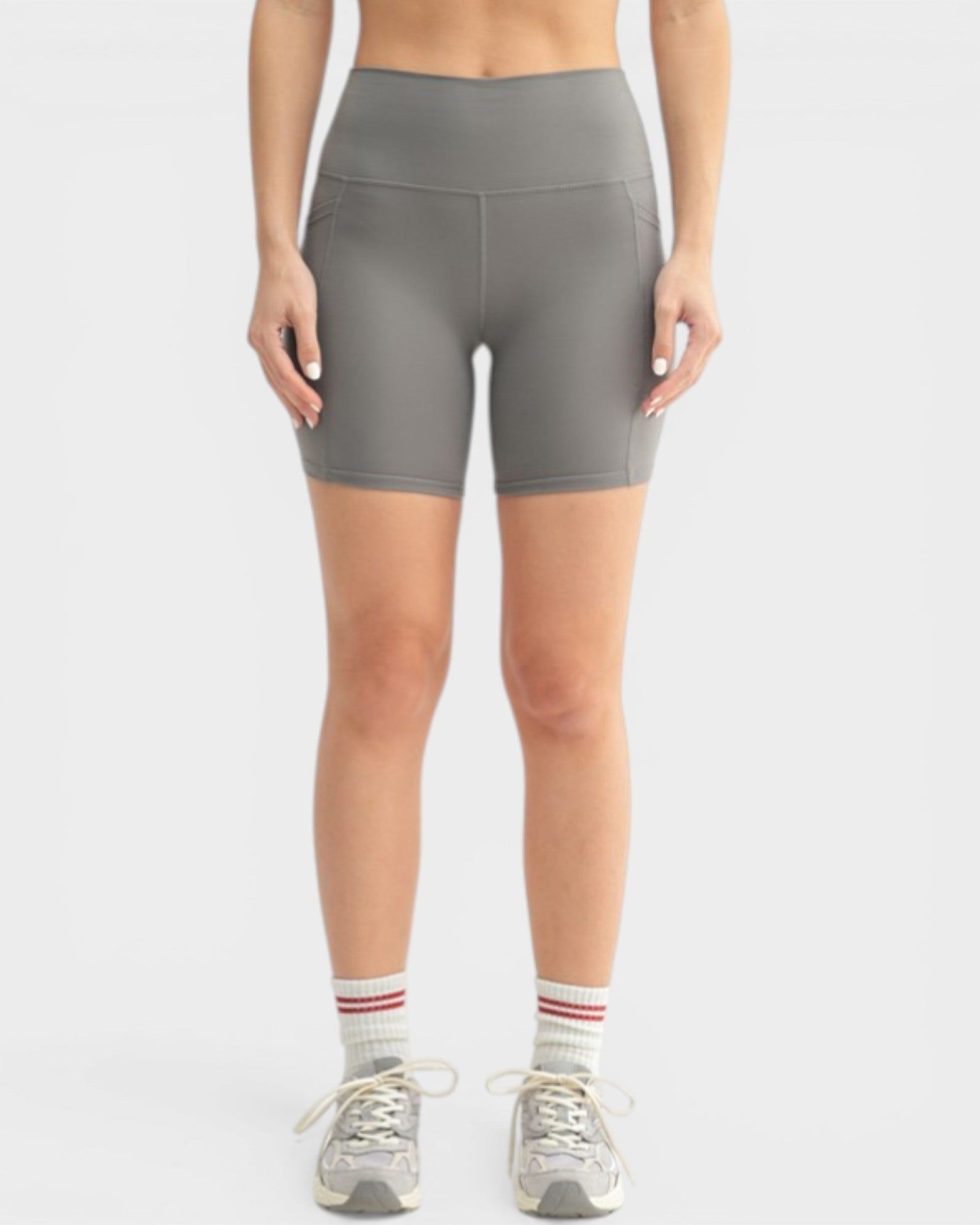 Person wearing gray high-waisted shorts on a white background