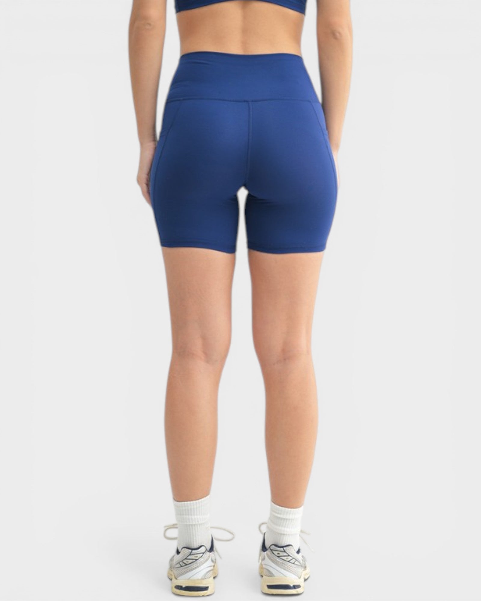 Person wearing blue athletic shorts on a white background