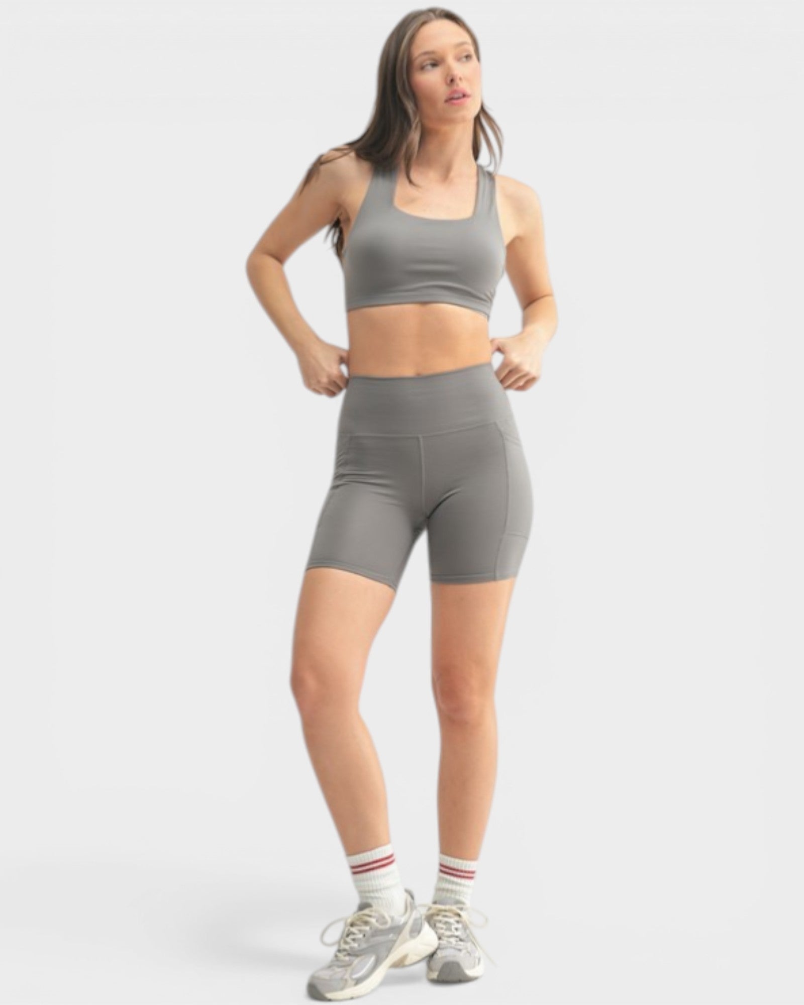 Woman wearing a gray athletic outfit on a white background