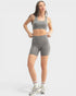 Woman wearing a gray athletic outfit on a white background