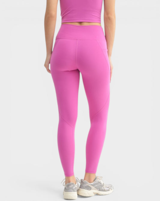 Person wearing bright pink leggings and a matching top on a white background