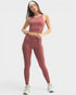 Woman wearing a pink athletic outfit on a white background