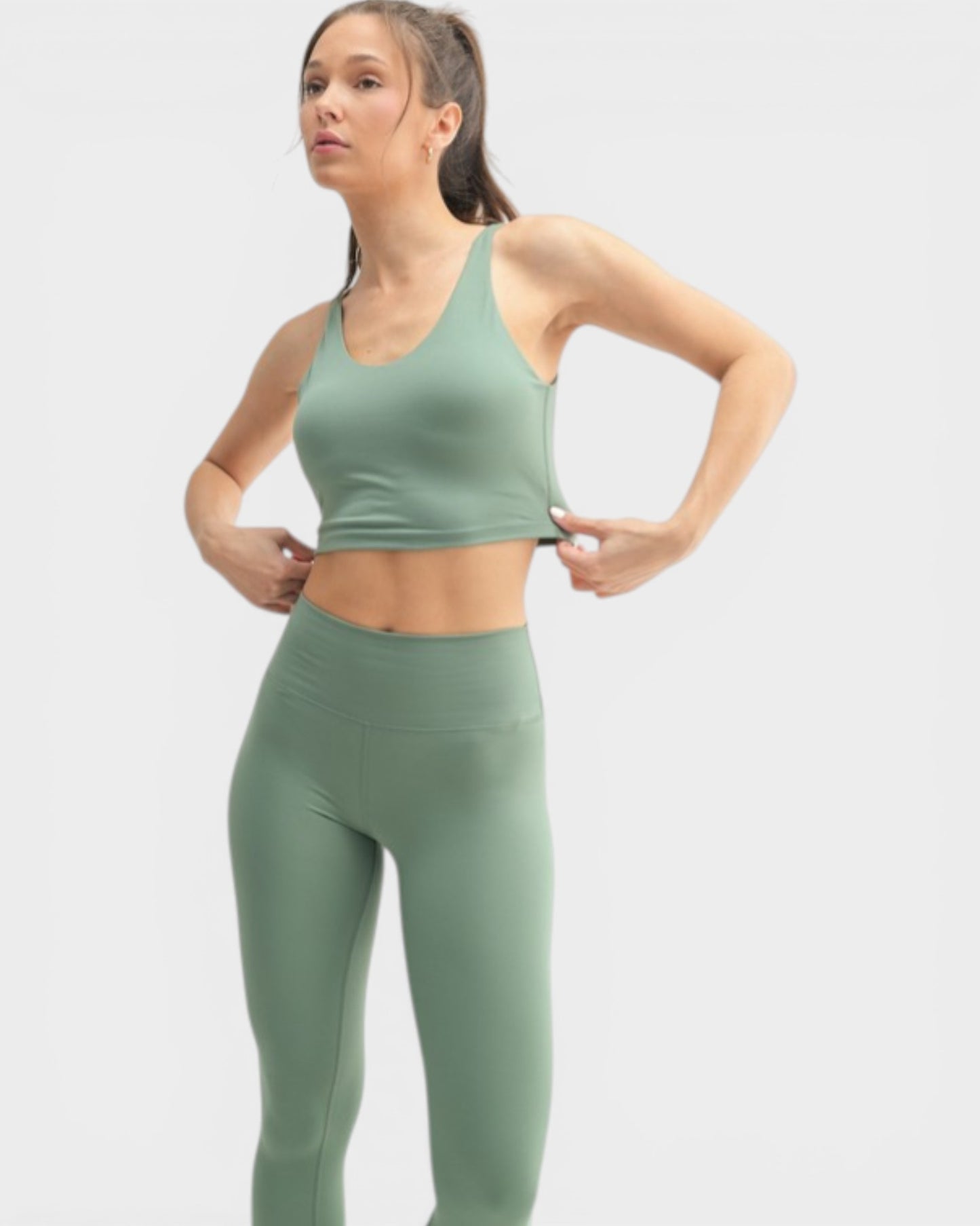 Woman wearing a green athletic outfit on a light gray background