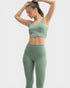 Woman wearing a green athletic outfit on a light gray background