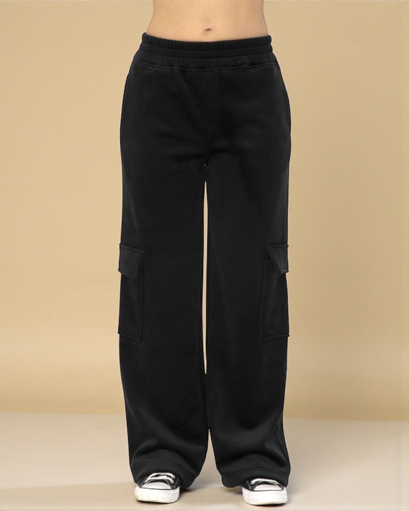 Black cargo pants on a beige background