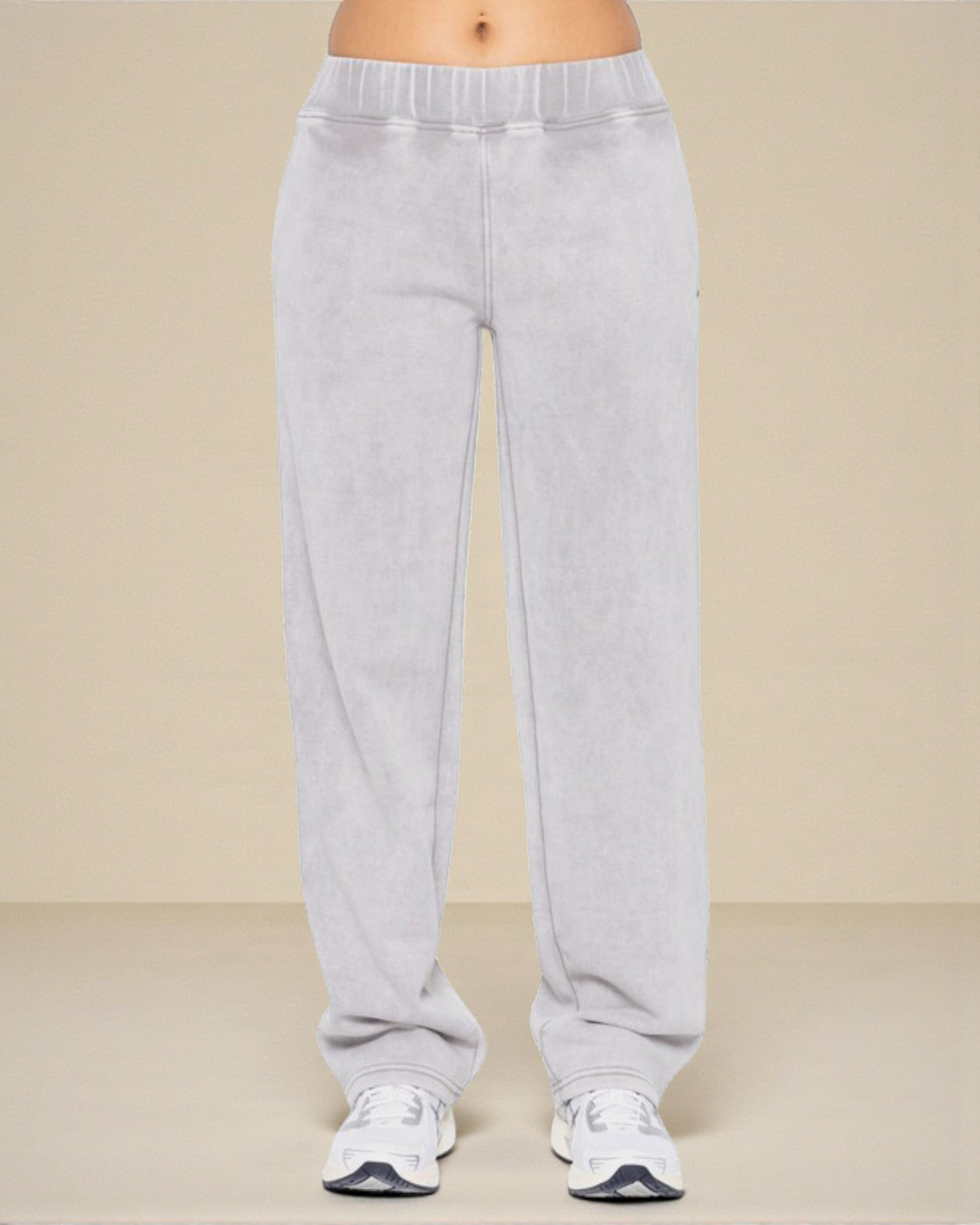 Gray sweatpants worn by a person on a beige background