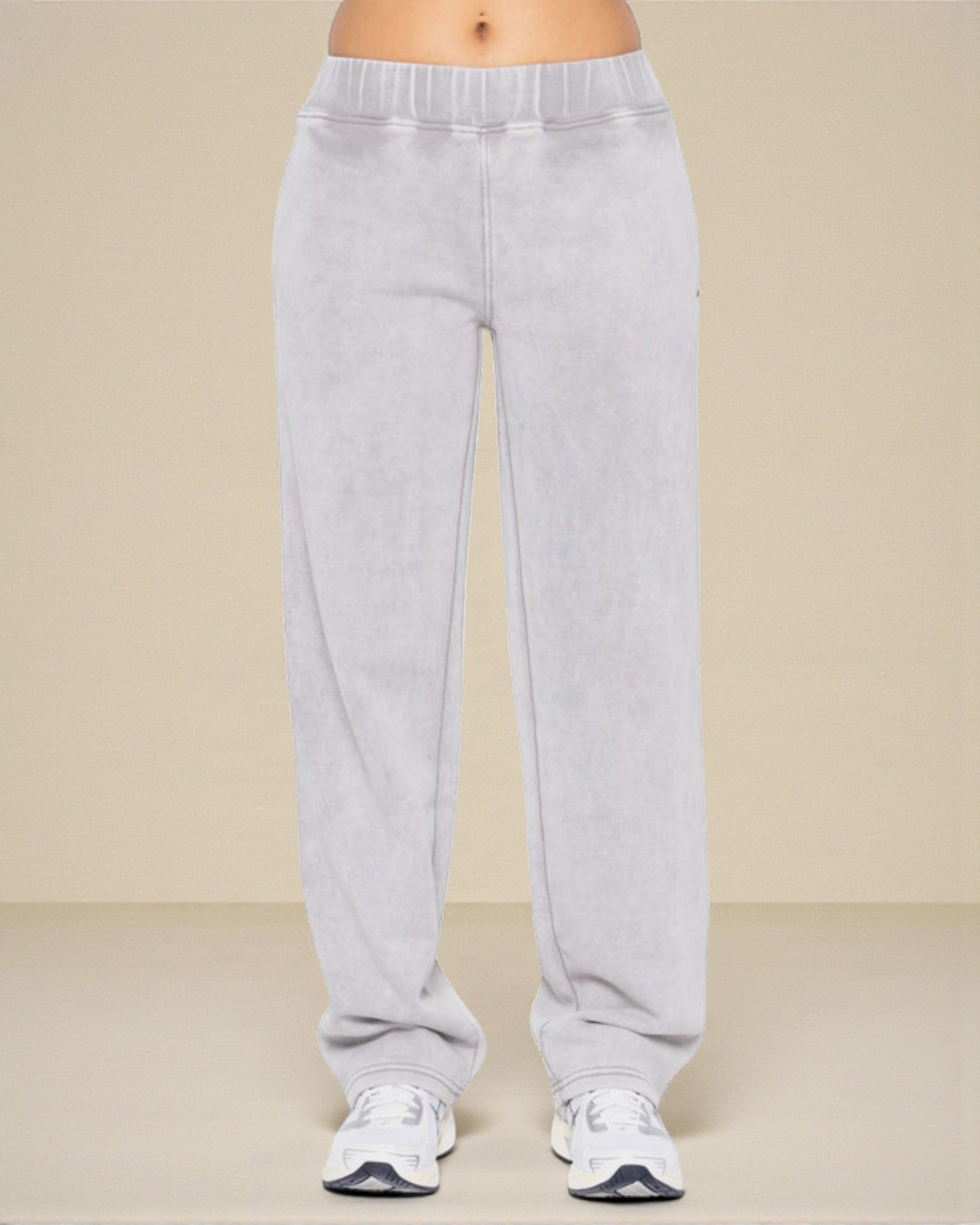 Gray sweatpants worn by a person on a beige background