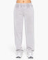 Light gray sweatpants worn by a model, shown from the waist down against a plain white background.