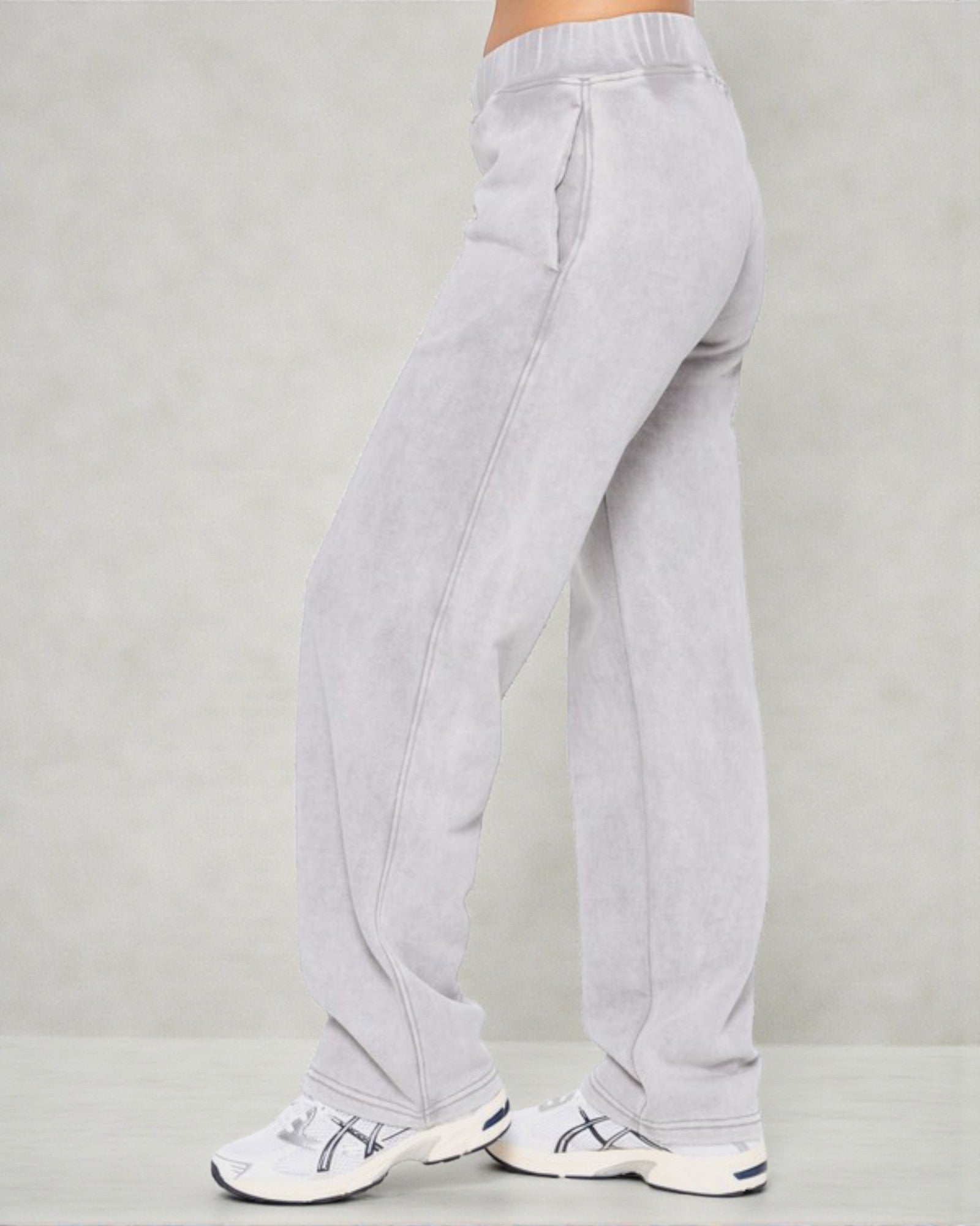 Light gray sweatpants worn by a person on a plain background