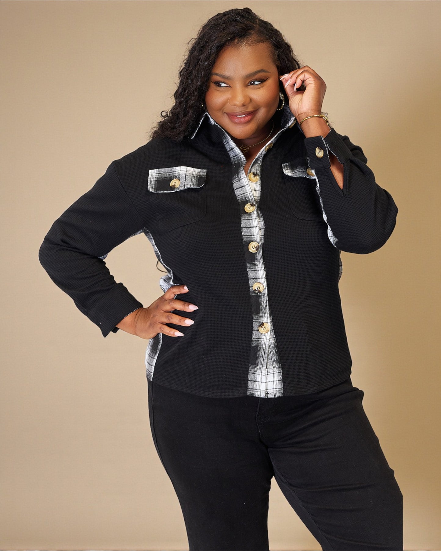 Woman wearing a black and plaid shirt with a beige background