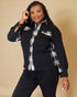 Woman wearing a black shirt with plaid accents on a beige background