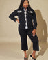Woman wearing a black outfit with plaid accents against a beige background