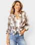 Woman wearing a plaid shirt and jeans on a plain background