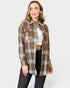 Woman wearing a plaid shirt over a white crop top on a white background