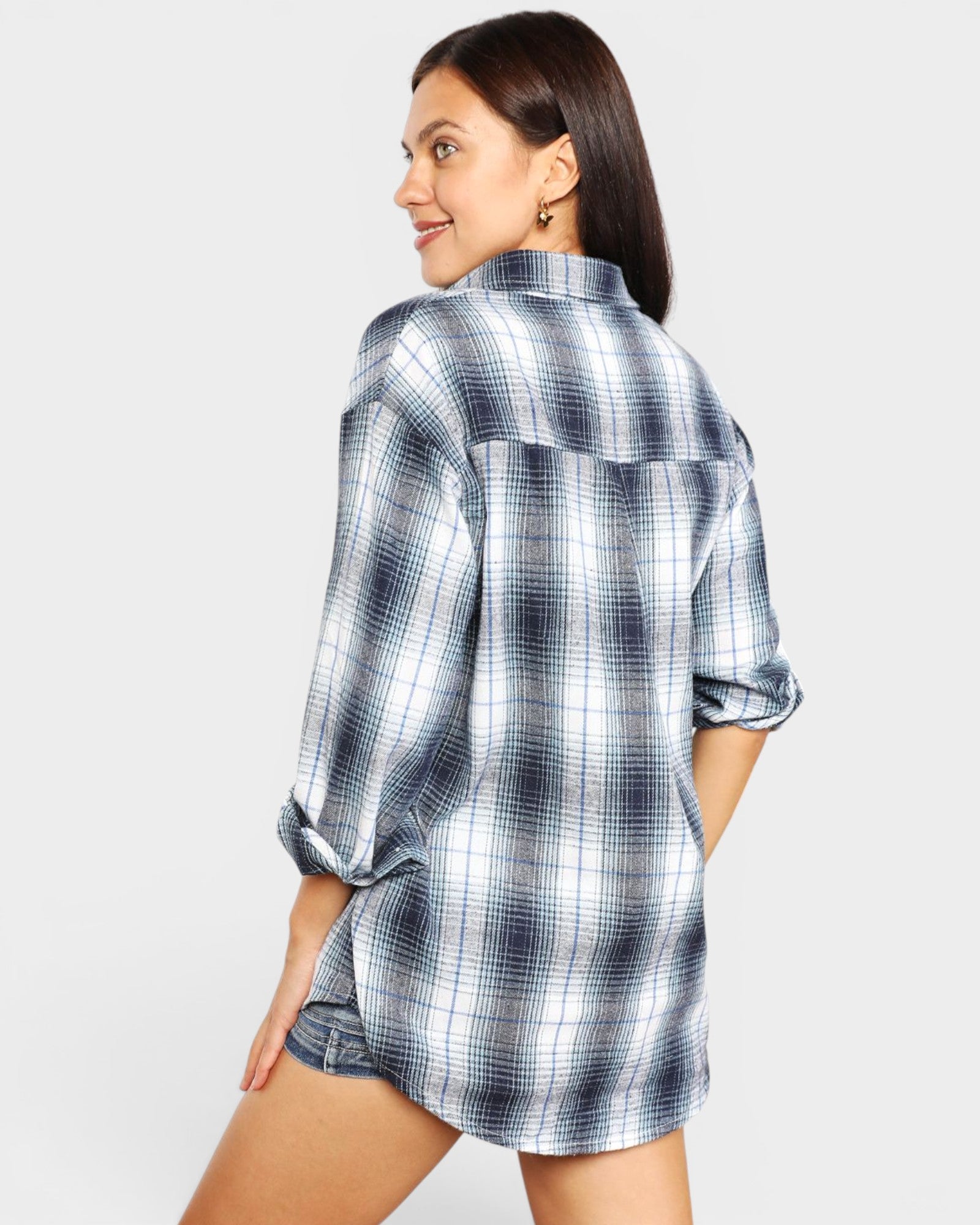 Woman wearing a blue and white plaid shirt on a plain background