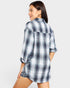 Woman wearing a blue and white plaid shirt on a plain background
