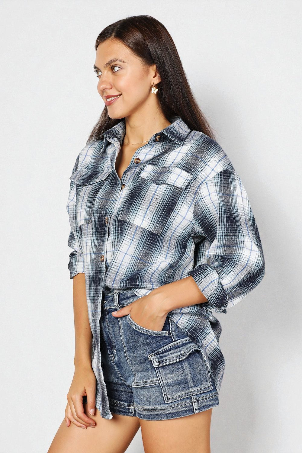 Woman wearing a plaid shirt and denim shorts on a white background