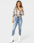 Woman wearing a plaid shirt, jeans, and white boots on a white background