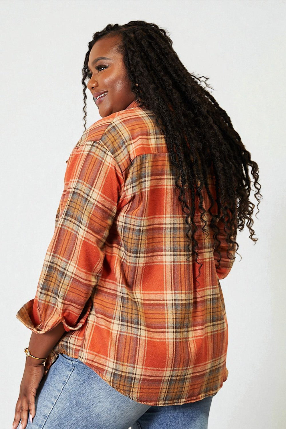 Person wearing an orange plaid shirt against a white background